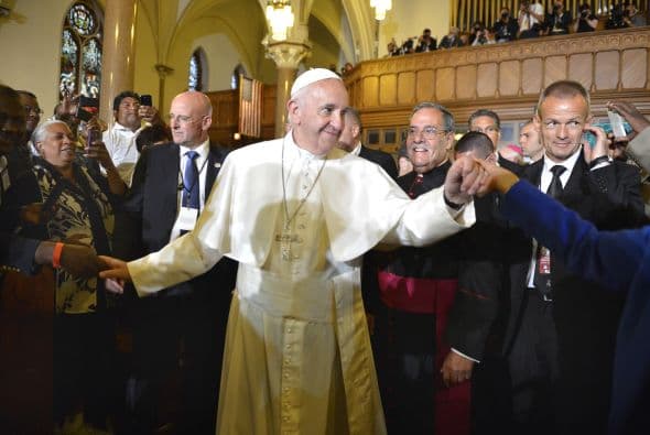 Francisco saluda con ambas manos a feligreses, inmigrantes y otras personas que trataron de estar cerca de él.