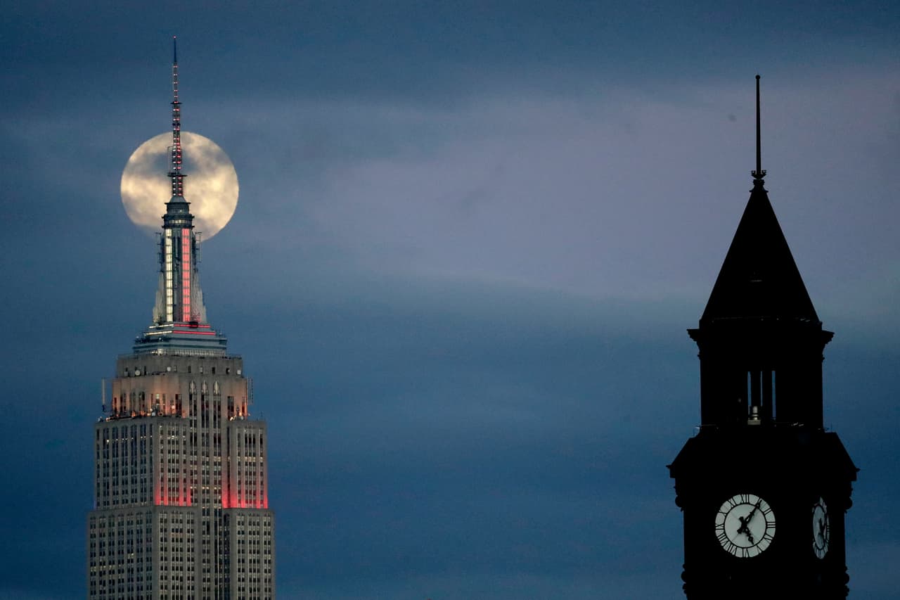 La súper luna de este domingo detrás de los edificios del Empire State, a la izquierda, y la torre Lackawanna, en Nueva York.