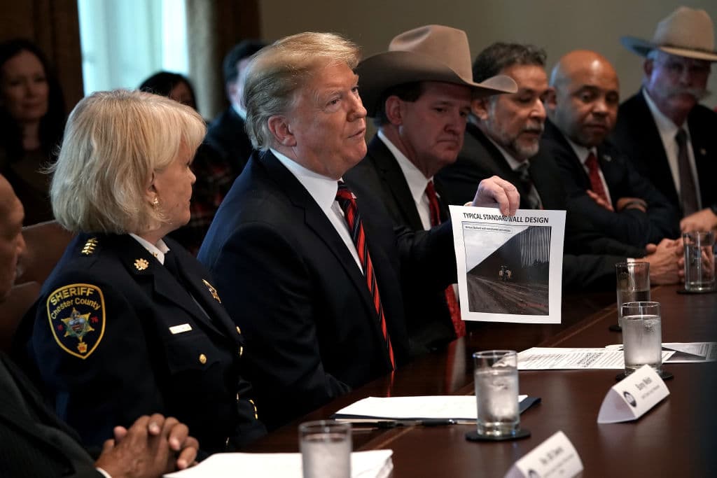 WASHINGTON, DC - JANUARY 11: U.S. President Donald Trump holds a picture labeled 'typical standard wall design' as he hosts a round-table discussion on border security and safe communities with State, local, and community leaders in the Cabinet Room of the White House on January 11, 2019 in Washington, DC. As the second-longest government shut down continues, Democrats and Republicans have not found a compromise for border security funding and President Donald Trump's proposed wall on the U.S.-Mexico border. (Photo by Alex Wong/Getty Images)