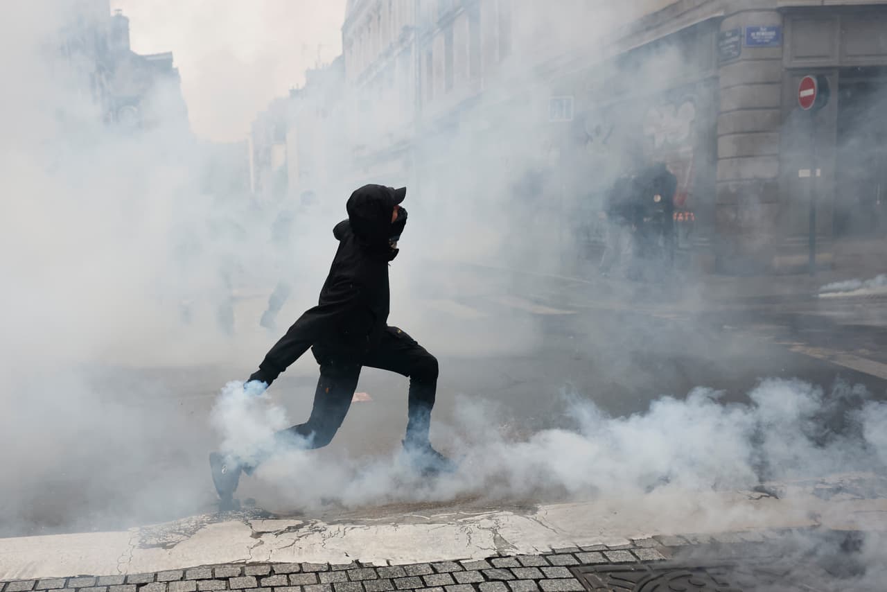 Un manifestante lanza una granada de gas lacrimógeno a la policía tras una protesta contra el aumento del coste de la vida en Rennes, Francia, el sábado 24 de octubre de 2026.