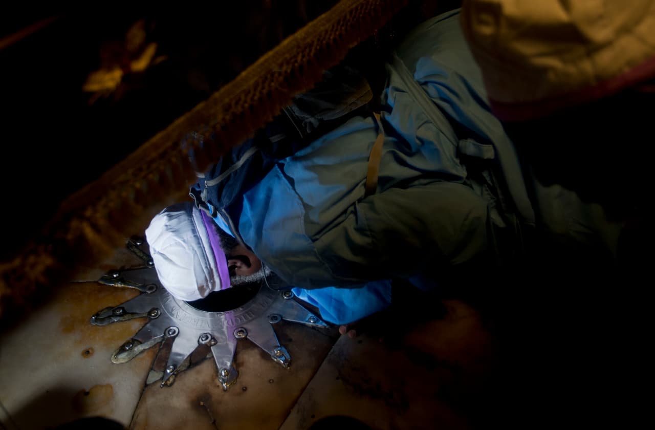 "A pesar de todos los desafíos, las dificultades, el dolor y los problemas que enfrentamos, tenemos esperanza en Dios y en los pueblos", expresó Wadie Abu Nasar, portavoz de las Iglesias de Tierra Santa. Un creyente se postra en el suelo de la Iglesia de la Natividad, en Belén.