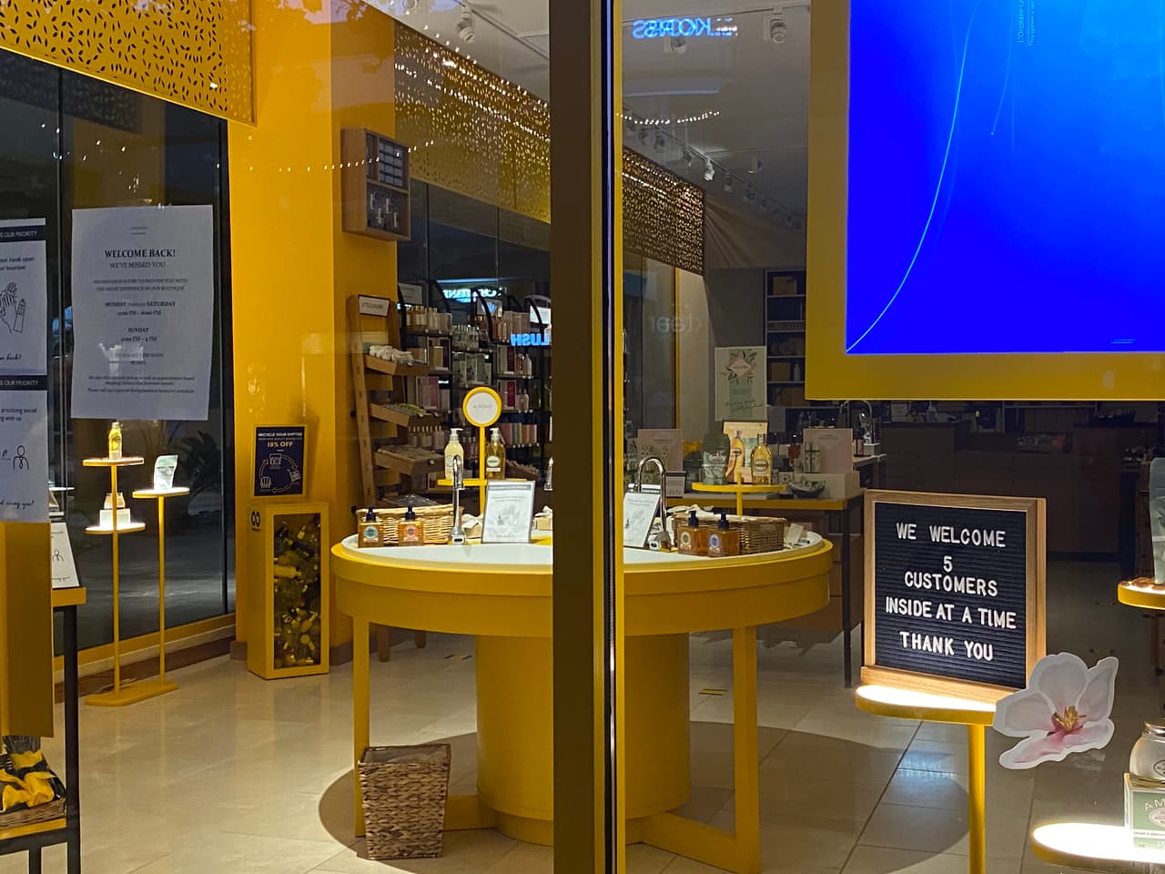 Esta tienda tiene letreros que indican las condiciones para ingresar, solo cinco clientes a la vez.