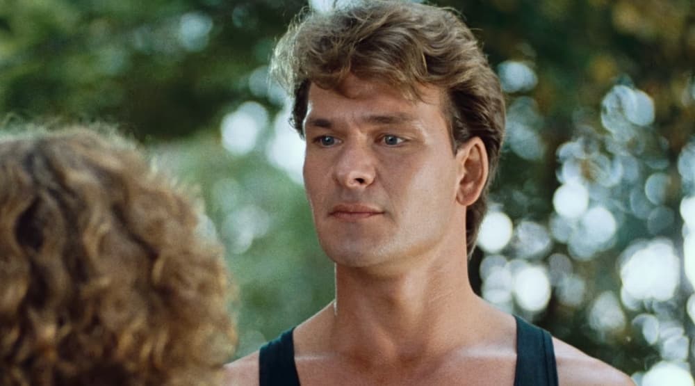 <b>Patrick Swayze - Johnny Castle </b>
<br>Johnny Castle era un popular instructor de baile en el resort Kellerman's, que tenía problemas para llegar a fin de mes a causa de su bajo salario y deudas. Cuando su pareja de baile se enferma, uno de sus trabajos mejor remunerados corre peligro. Afortunadamente, 'Baby' está ahí para ayudarlo.