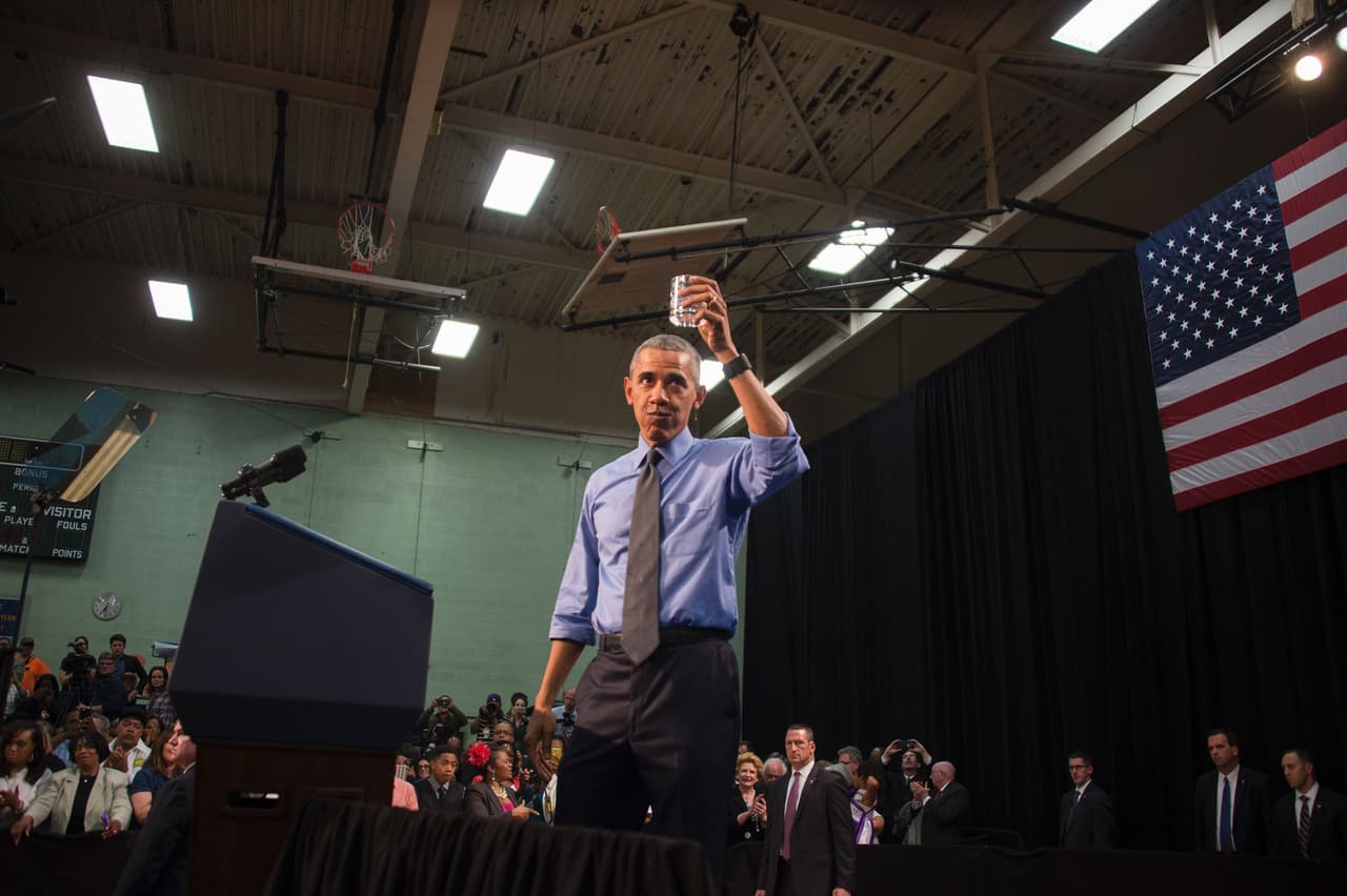 Presidente Barack Obama toma un vaso de agua cuando habla en Flint Northwestern High School en Flint, Michigan el 4 de mayo, 2016.