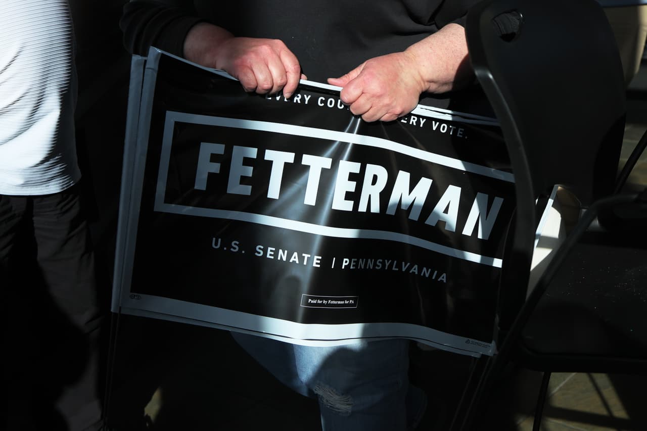 Un partidario lleva un cartel de campaña para el Vicegobernador de Pensilvania John Fetterman, el favorito de las primarias demócratas en un campo que incluye al representante estadounidense Conor Lamb y al senador estatal Malcolm Kenyatta, compitiendo para reemplazar al senador republicano Pat Toomey, quien se jubila.