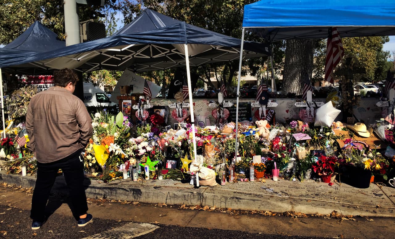Un hombre observa el homenaje en la calle a las víctimas del tiroteo de Thousand Oaks, en California.