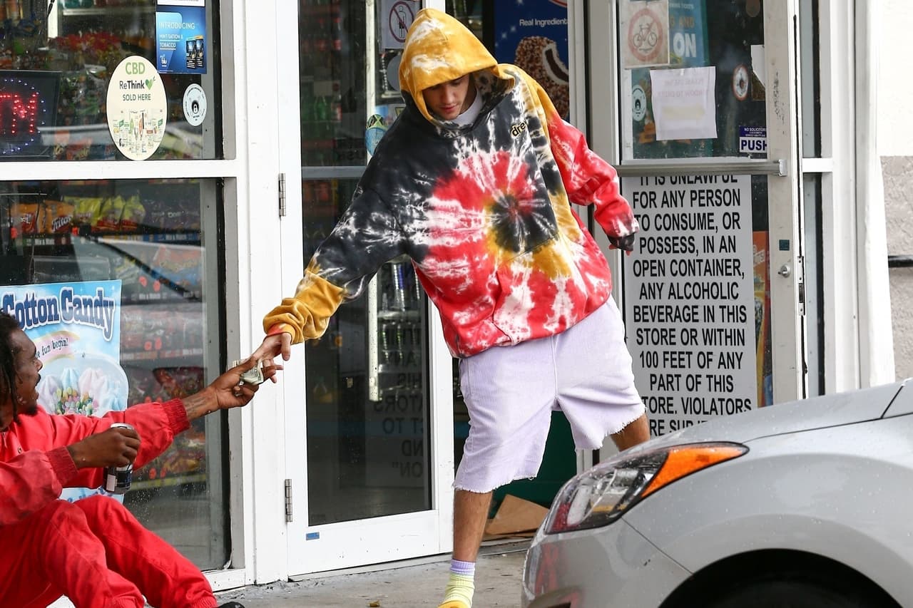 Y le entregó 40 dólares en la mano a la persona que yacía sentada en el suelo.