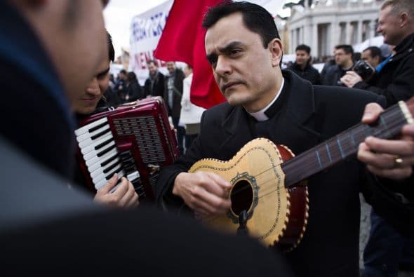 En la tierra, sobre los adoquines de la plaza, miles de curiosos y peregrinos de nacionalidades de todo el mundo empezaban a abarrotar la plaza, inundándola de un ambiente festivo mientras tañían sus guitarras y entonaban cánticos en honor a un pontífice "honrado".