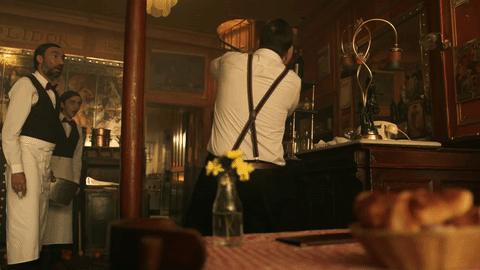 Mojado, se tambalea y cae encima de la mesa de la chica, destrozándola.