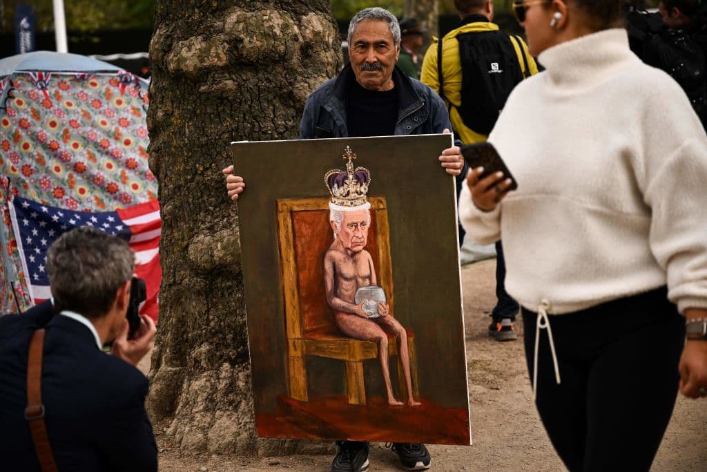 El artista de sátira política, Kaya Mar, sostiene un cuadro en el que aparece el rey Carlos III.