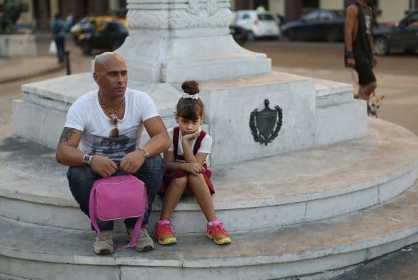 Yendri Campos Pachego y su hija Llorena, de 5 años, esperan a que la madre de la niña pase a recogerla después de la escuela.