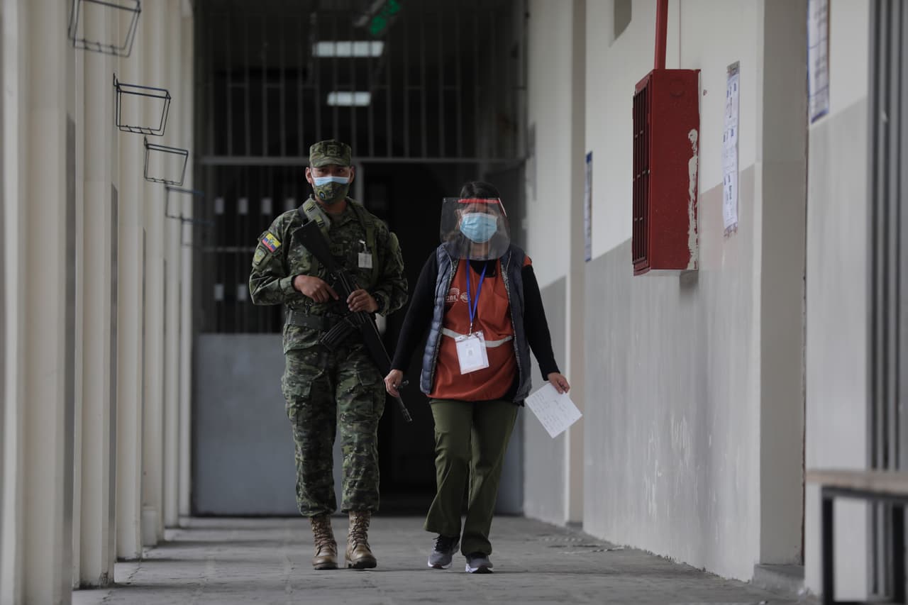 Un militar patrulla un precinto electoral en Quito. En un boletín informativo, el Consejo Nacional Electoral de Ecuador informó que cerca de 45,000 polícias y 37,000 funcionarios de las Fuerzas Armadas habían sido desplegados para resguardar el voto.