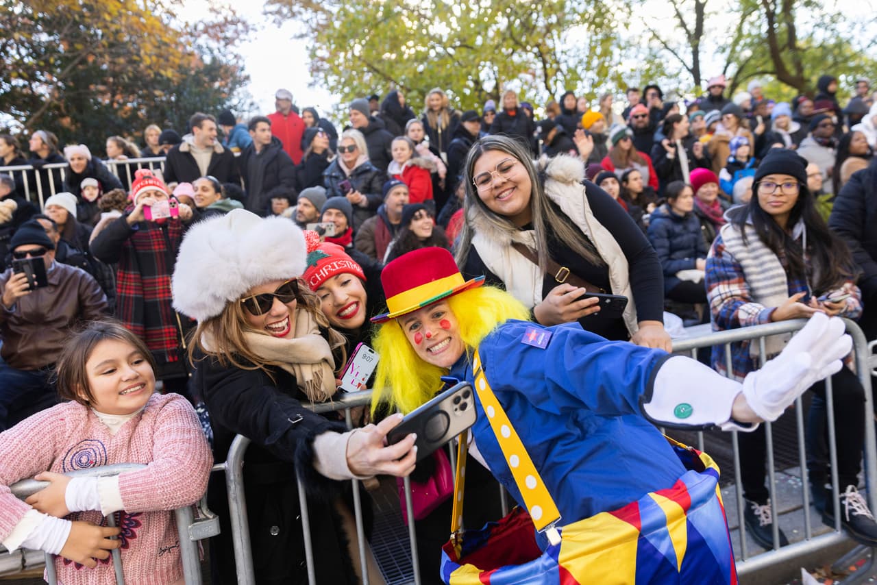 Los espectadores se toman una selfie con un artista en Central Park West durante el desfile del Día de Acción de Gracias de Macy's, el jueves 23 de noviembre de 2023, en Nueva York.