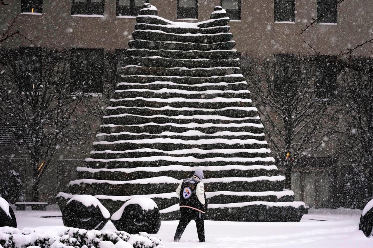 Una persona pasa junto a unas escaleras nevadas en el centro de Pittsburgh.