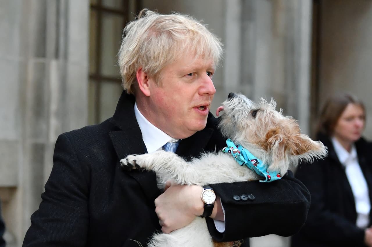El premier británico Boris Johnson sostiene a su perro Dilyn después de votar este jueves en Londres.