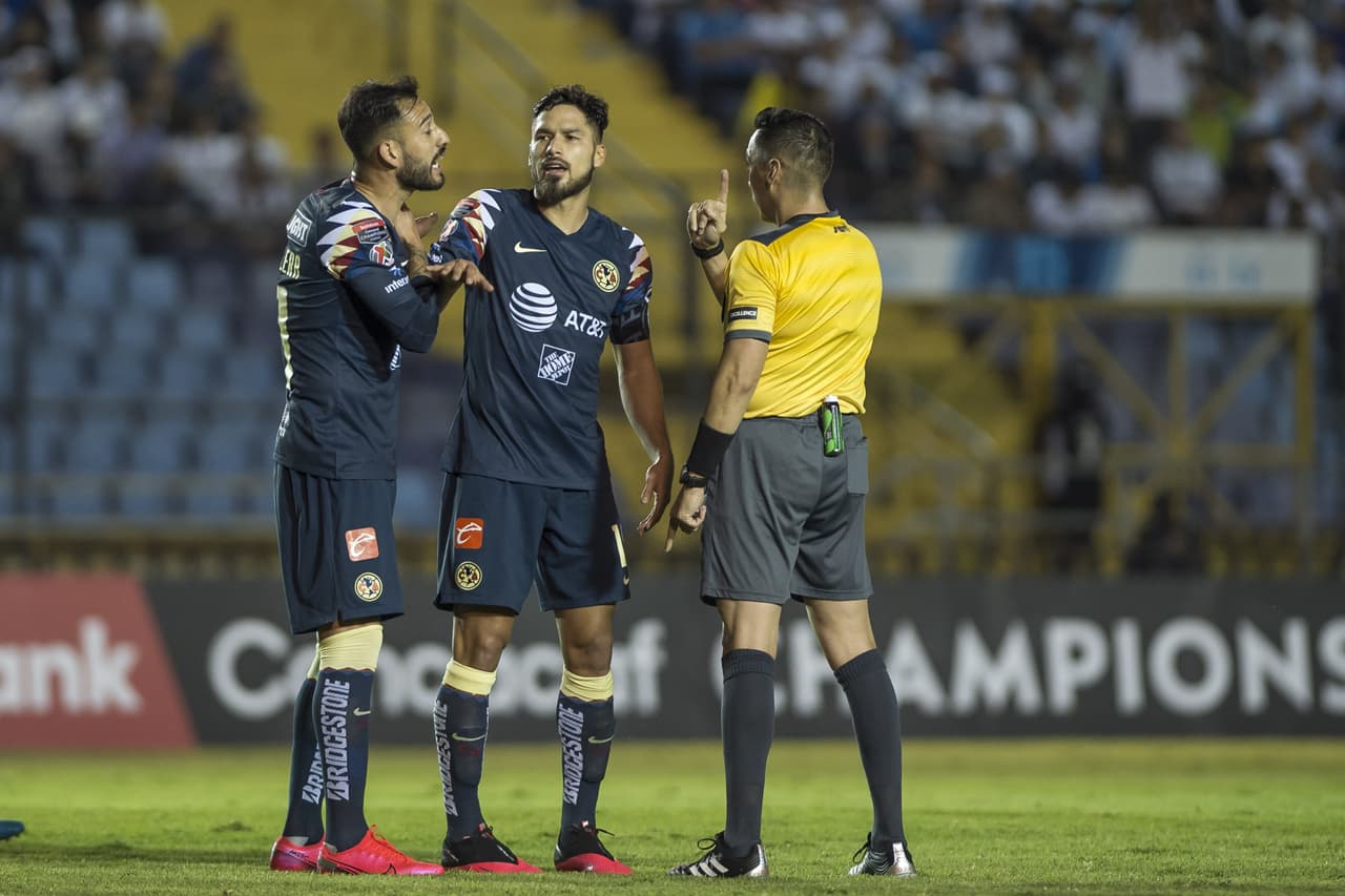 Los jugadores del América le reclaman al árbitro ya que no se atreve a sacar las tarjetas.