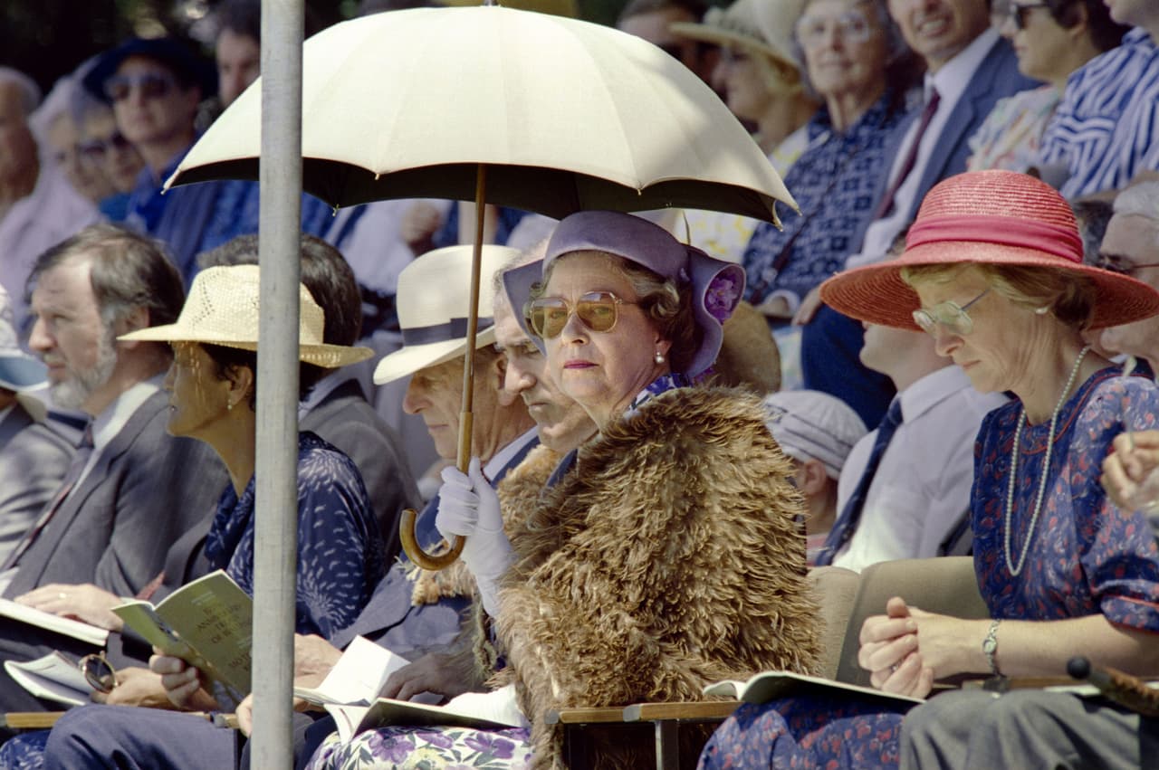Protegiéndose del Sol con una sombrilla, en una ceremonia en Nueva Zelanda en 1990.