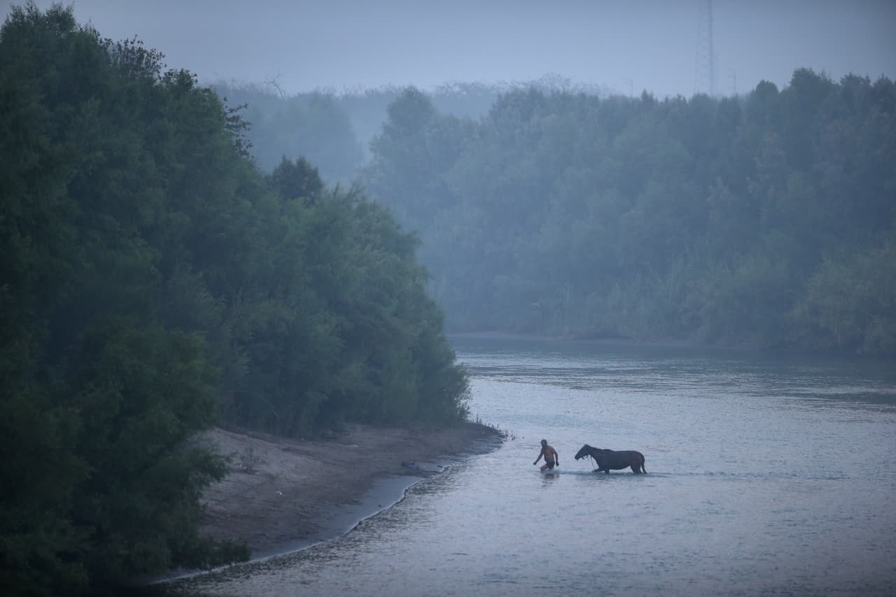 <b>Mision, Texas.</b> Un hombre pasa al lado mexicano del Río Bravo, luego de lavar su caballo del lado estadounidense.