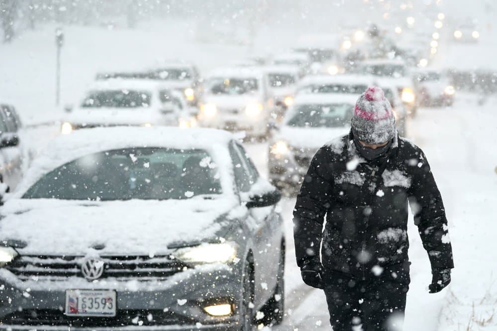 Miguel Reider camina cerca de un atasco de tráfico causado por vehículos atascados en una colina durante una tormenta de nieve, el miércoles en Towson, uno de los condados de Baltimore, en Maryland.