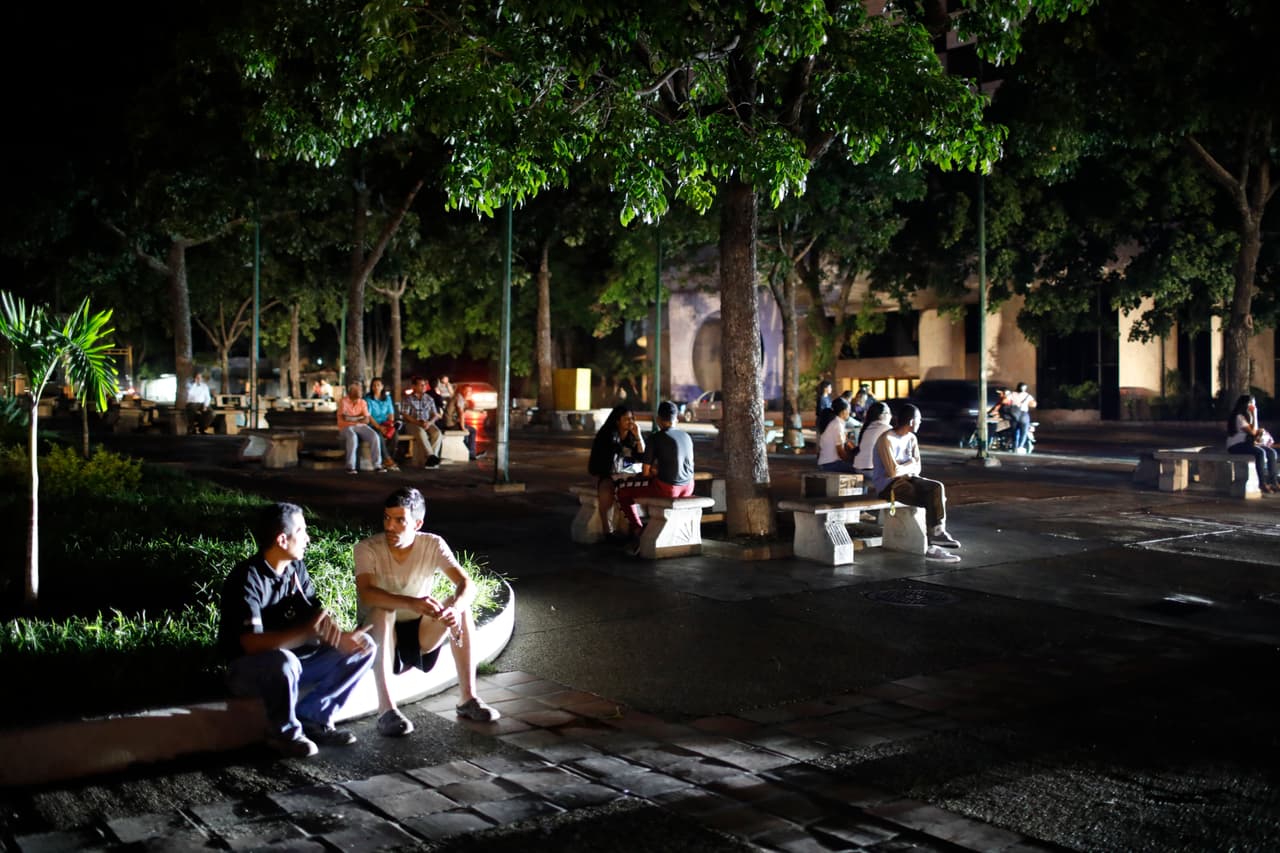 Personas esperando sentadas en una plaza de Caracas a que se restituya el servicio eléctrico. El 7 de marzo se registró el que hasta ahora ha sido el peor apagón en la historia venezolana, que se prolongó cuatro días a nivel nacional. Aquellas fallas no sólo provocaron interrupciones en las comunicaciones (internet y telefonía), sino también problemas en el suministro de agua.