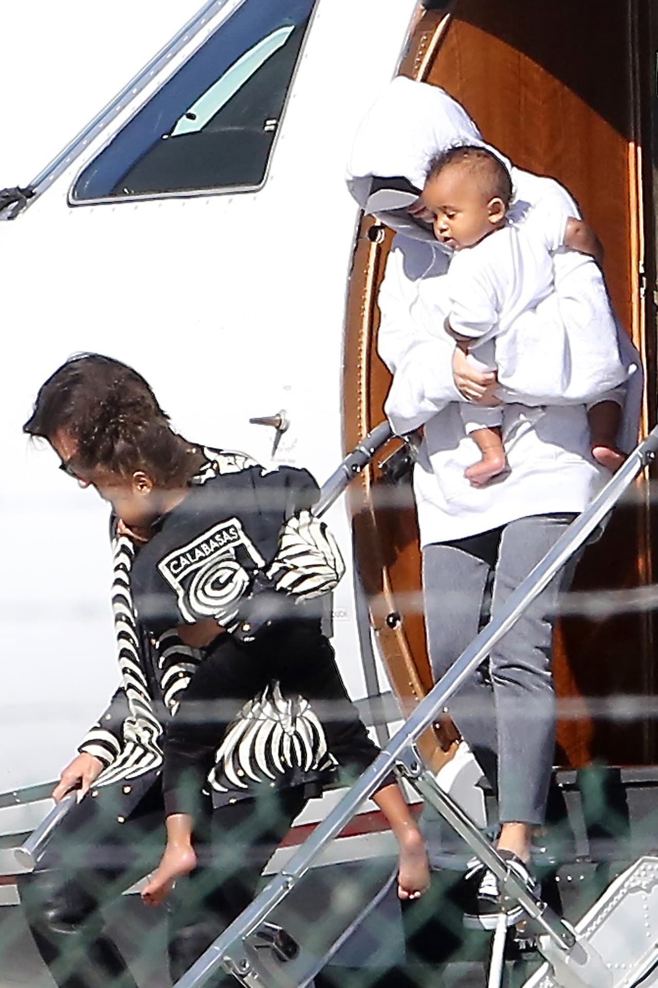 Justo detrás venía Kim Kardashian cargando a Saint.