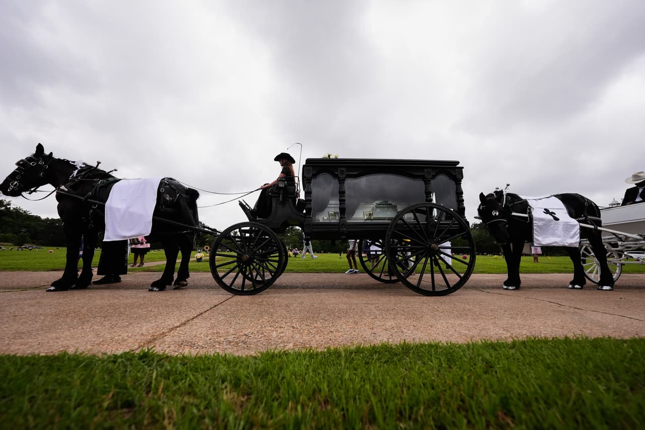 El sábado 9 de mayo de 2026, en el cementerio Forest Park West de Shreveport, Luisiana, los carros fúnebres transportan los ataúdes de ocho niños que murieron en un tiroteo masivo el mes pasado. (Foto AP/Gerald Herbert)