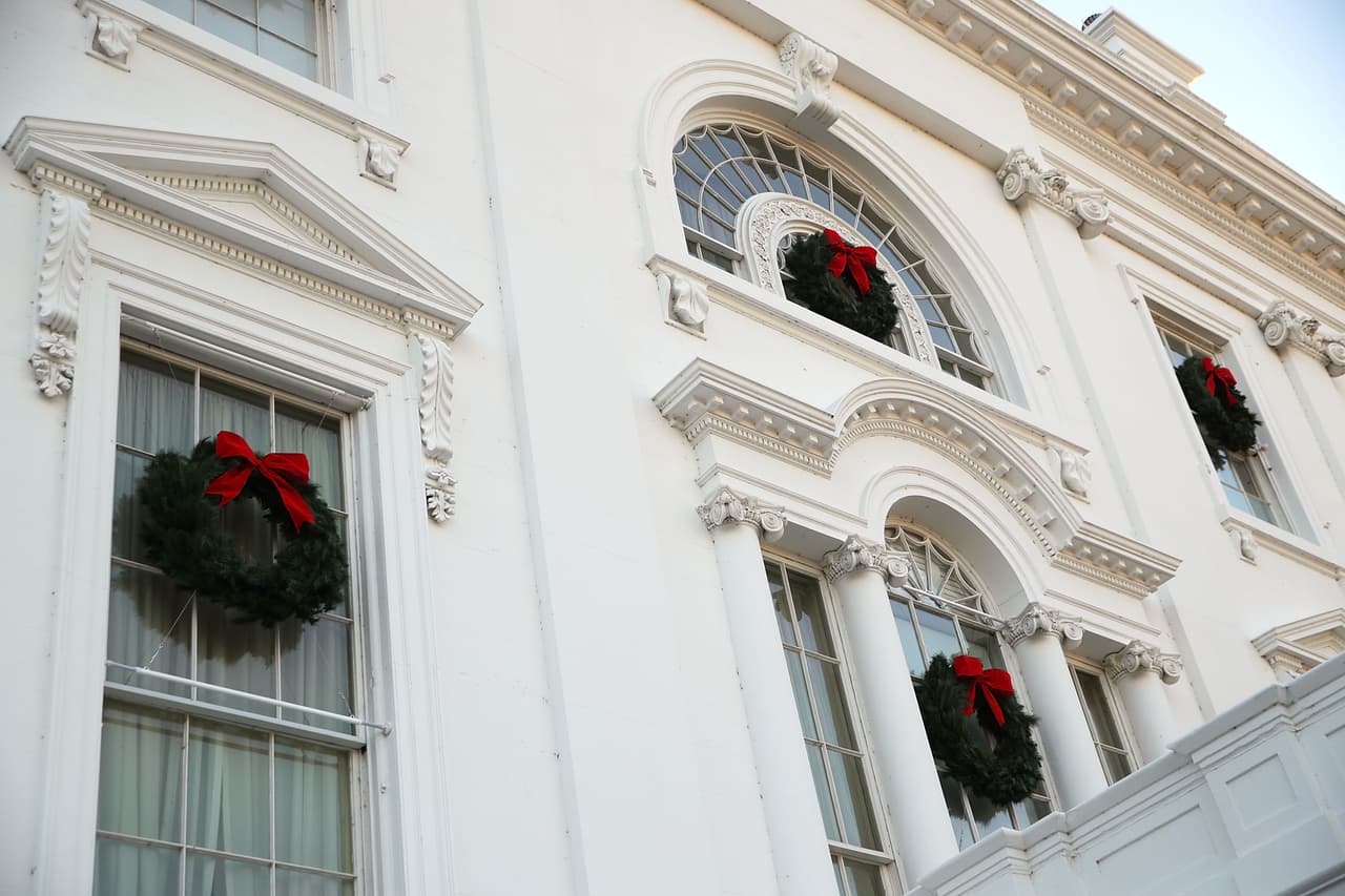 Unas sencillas coronas de navidad hechas de ramas de pinos coronadas con un lazo rojo se colocaron en lado exterior de las ventanas de la mansión.