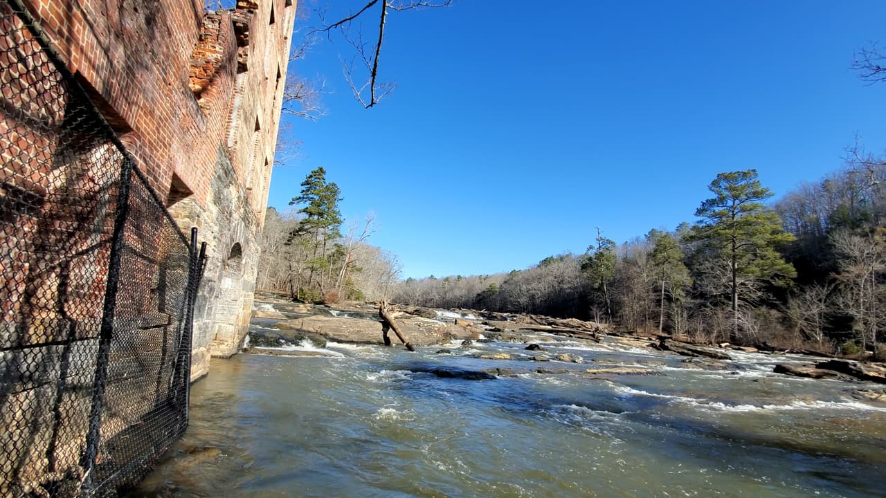 Si continúas por el sendero rojo, eventualmente podrás bajar unos escalones y apreciar las ruinas desde el nivel del arroyo.