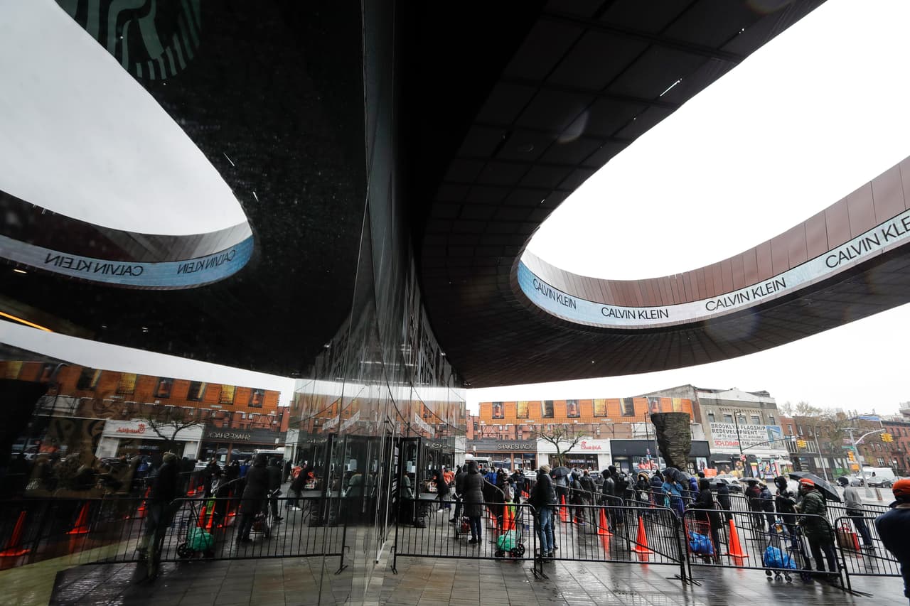 Personas esperan en la lluvia