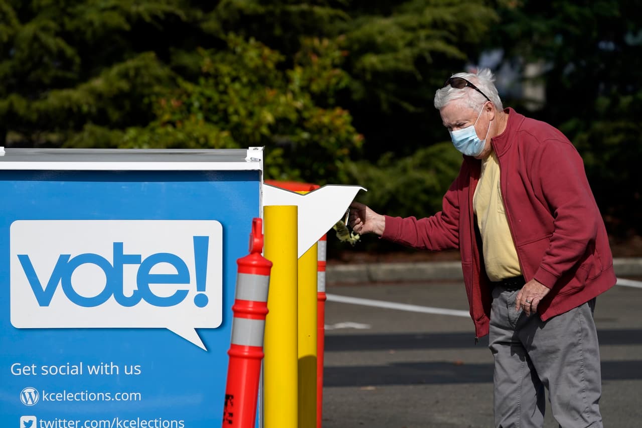 Un votante deja caer su boleta en un buzón frente a una oficina de elecciones en Tukwila, Washington, el 13 de octubre. Junto a Colorado, Hawaii, Oregon y Utah, este estado realizará las elecciones en su totalidad mediante votación por correo.