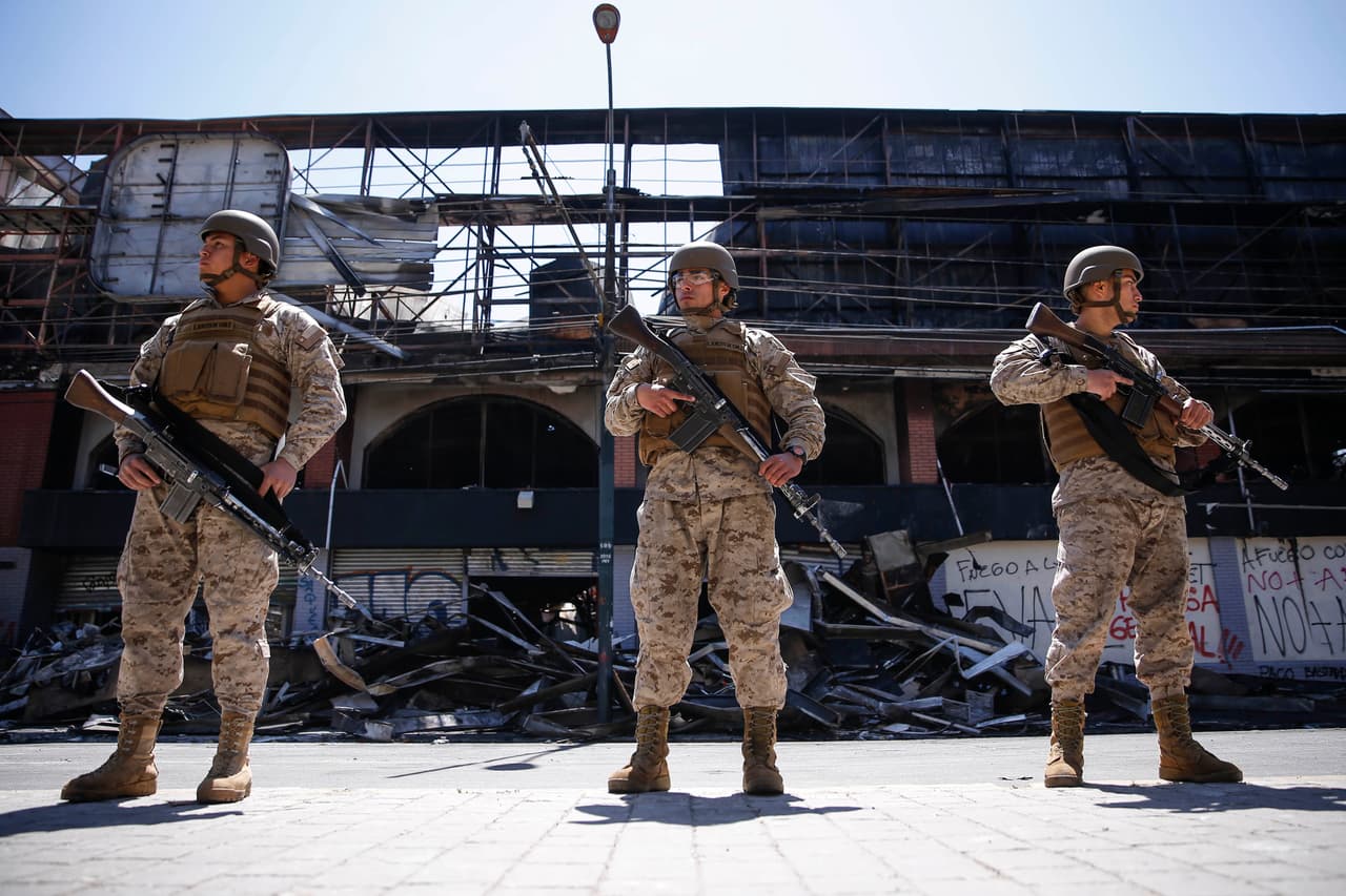 <b>Un grupo de soldados resguarda las ruinas de un supermercado</b> en Valparaiso, puerto a unas 80 millas al noreste de Santiago, que fue quemado la madrugada del domingo. En esta ciudad no había sido establecido que de queda impuesto como sucedió en la capital desde la noche del sábado.