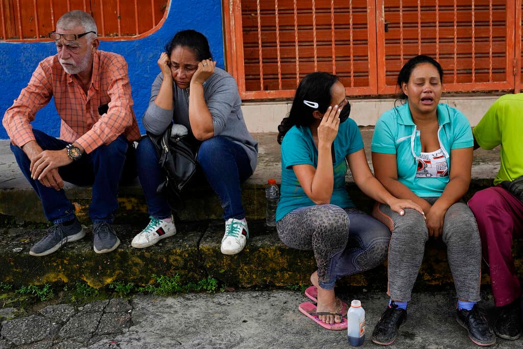 Residentes de Las Tejerías esperan en el exterior de un centro de atención médica información sobre sus familiares desaparecidos en el deslave.