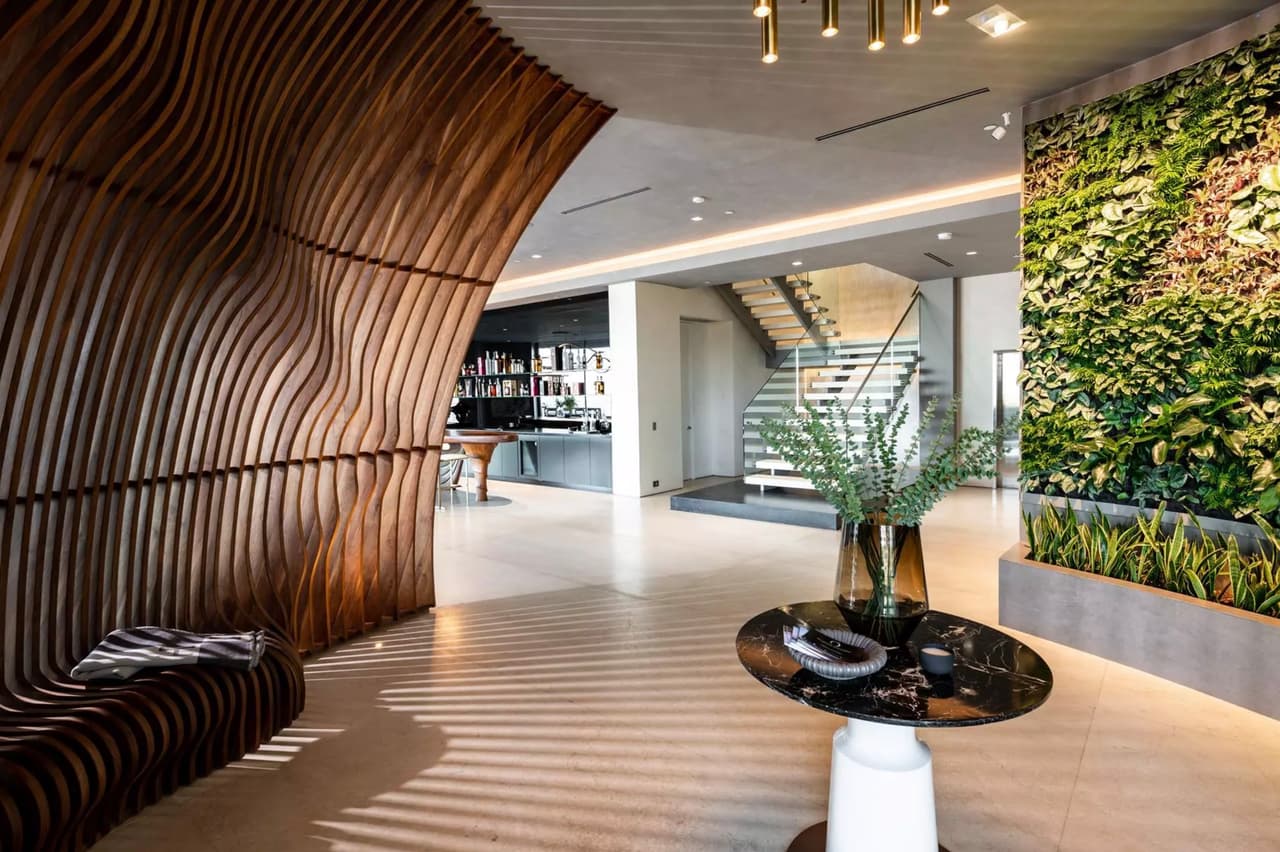 En la entrada principal de la casa existe una escultura de nogal diseñada por el japonés Toshi Kawabata, la cual se encuentra "frente a una 
<b>pared verde de 12 pies</b> que actúa como un 
<b>purificador de aire natural</b>", detalla Dirt. 
<br>