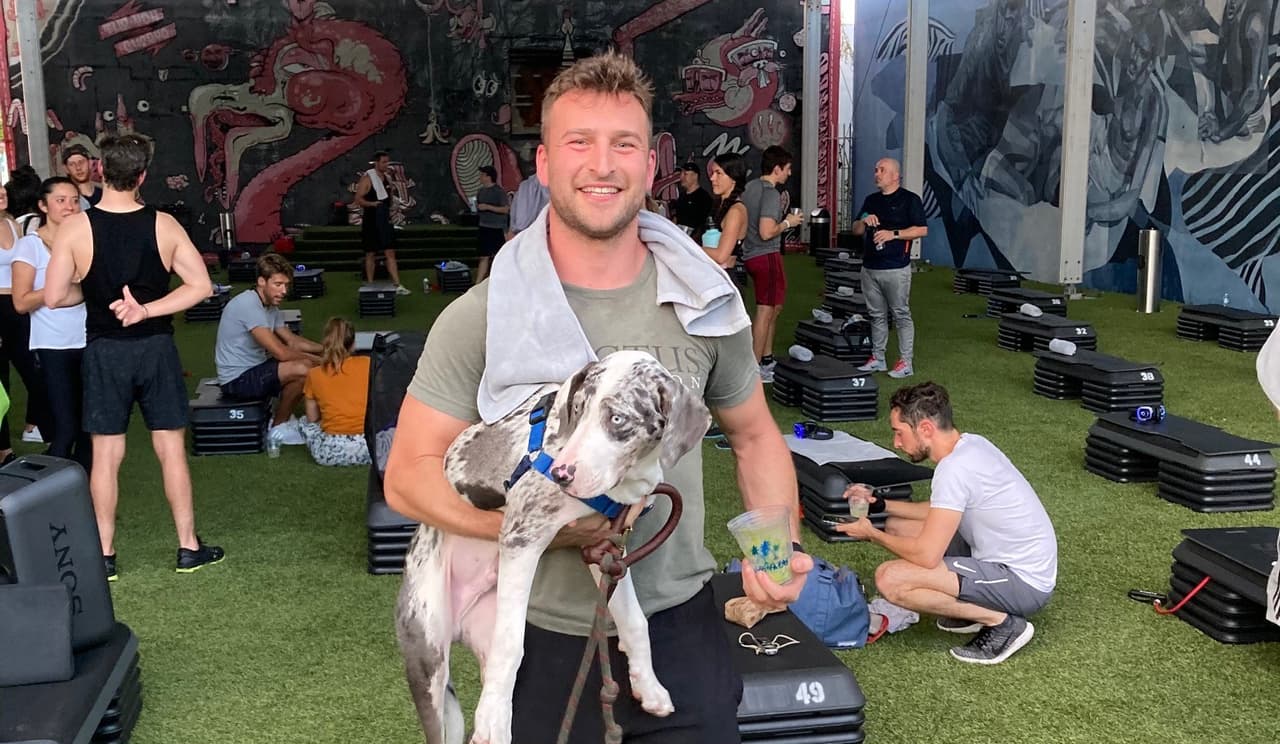 Jake Schuster con su perro, Maverick, en Barry's Boot Camp, un gimnasio al aire libre.