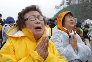 Familiares de jóvenes atrapados en el ferry hundido en Corea del Sur rezan y lloran a la orilla del mar frente a la zona de la tragedia.