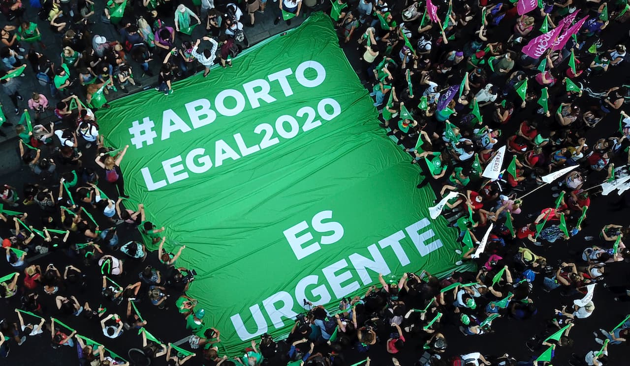 Activistas en favor de la legalización del aborto en Argentina con una bandera frente al Congreso que dice "Aborto legal 2020, es urgente". El presidente Alberto Fernández envió un proyecto de ley para legalizar el aborto que avanza en el Congreso.