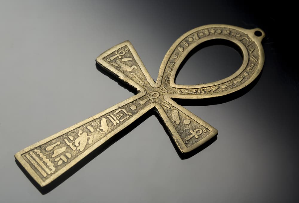También está la clásica cruz egipcia, o el Ankh, el amuleto más antiguo de Egipto. Similar a la cruz cristiana, pero con una forma ovalada arriba en forma de asa. Representa la vida, tanto terrenal como la eterna. Aparece portado por casi todas sus deidades, como símbolo de una llave al más allá.