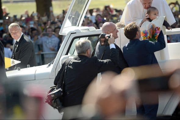 Francisco besa y bendice a un niño cuya familia le esperaba en las calles del Elipse.