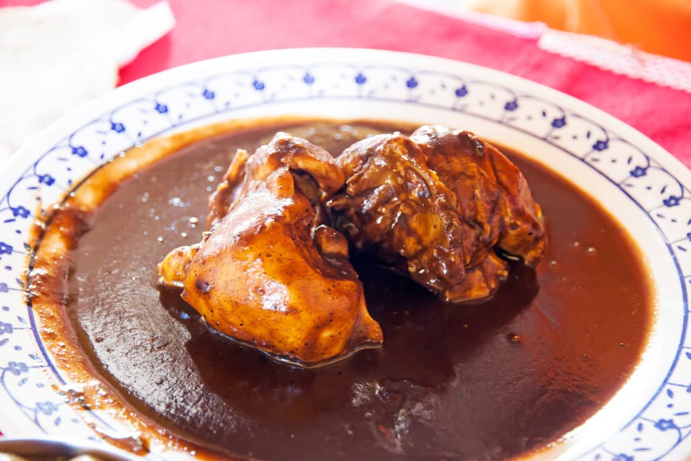 Mole Rojo. Este mole es con pollo y es más picante, con un sabor más definido. Se prepara con chocolate, chiles guajillo y ancho, cebolla, jitomate, ajo, orégano, canela, nueces, cacahuate y ajonjolí.
