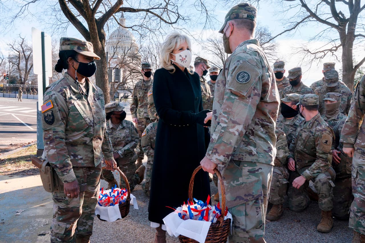 Al decir, Los Biden son una familia de la Guardia Nacional, la primera dama Jill Biden saluda a los miembros de la Guardia Nacional con galletas con chispas de chocolate fuera del Capitolio el 22 de enero de 2021, en Washington, DC.