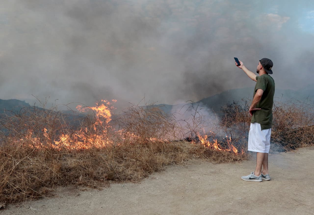 Un vecino del sector toma fotos del descomunal incendio cerca de Los Ángeles