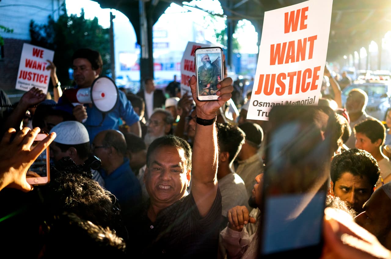 Manifestantes cerca de la escena del crimen exigen justicia por el asesinato del imán Maulama Akonjee.