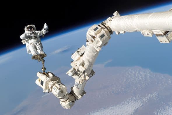 Montado sobre un brazo robótico, el astronauta Stephen K. Robinson, especialista de la misión STS-114, realizó reparaciones en el transbordador Discovery en agosto de 2005, siendo la primera vez en la historia del programa de transbordadores que las reparaciones del escudo de protección se realizaban mientras la nave está en órbita.