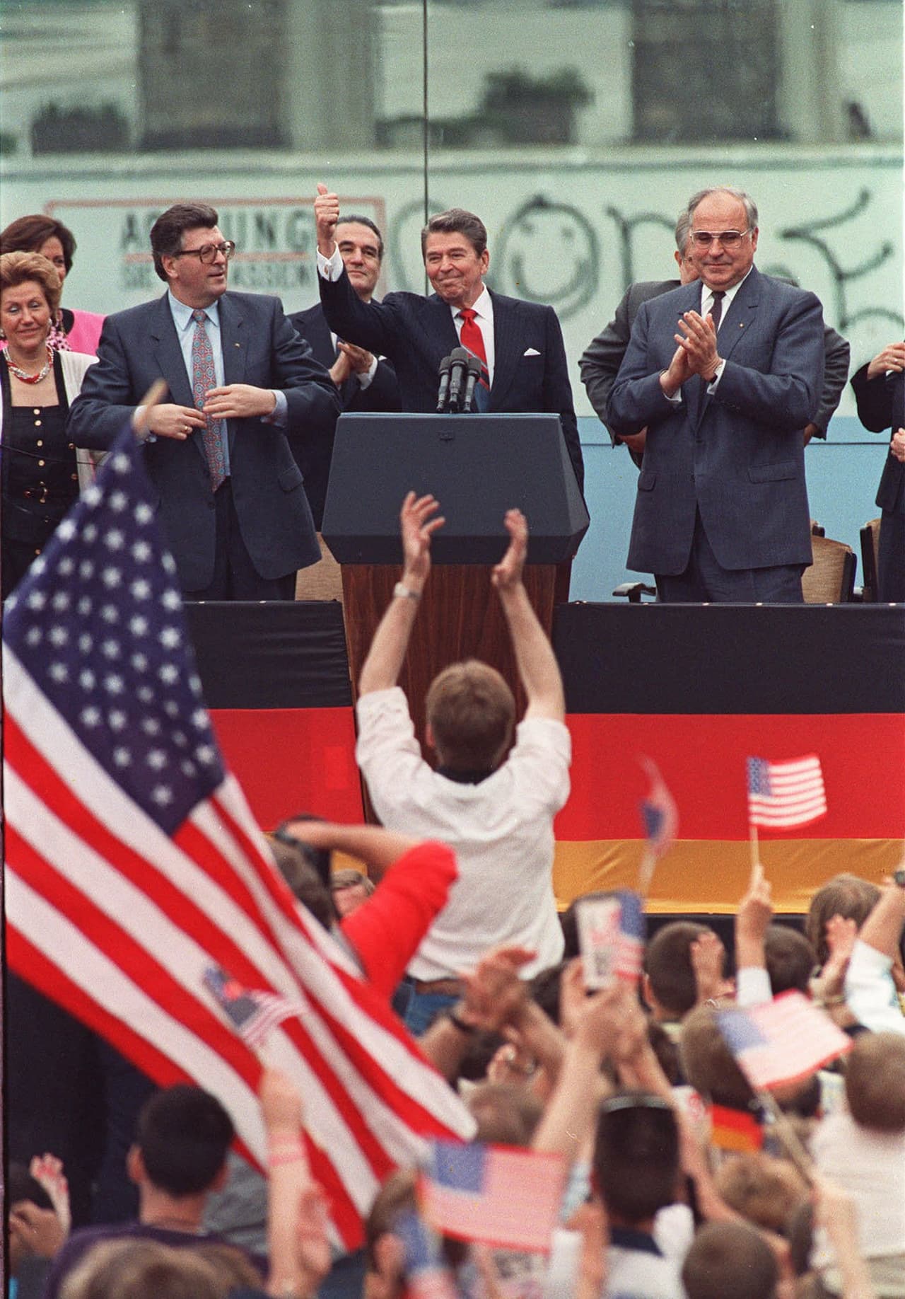 Con el muro de Berlín al fondo y más atrás la Puerta de Brandemburgo, Ronald Reagan es aplaudido luego de su discurso el 12 de junio de 1987. Junto a él las autoridades de Alemania occidental. “Señor Gorbachov, derribe esta pared”, le había dicho minutos antes al secretario general del partido comunista soviético, que se encontraba presente.
