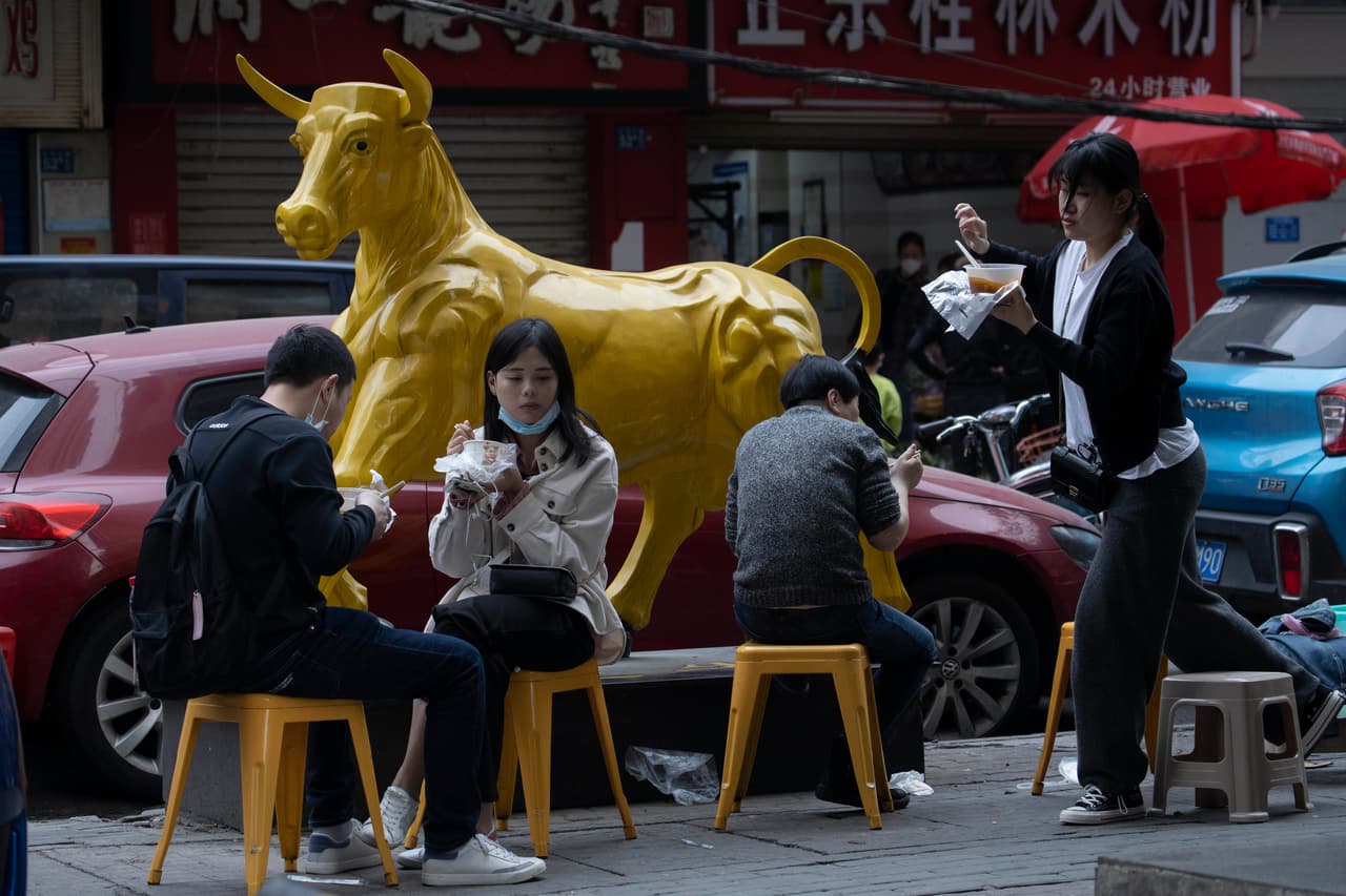 Un grupo de jòvenes comiendo en un restaurante callejero. Durante los 76 días de confinamiento, los residentes de Wuhan podían salir de sus casas solo para comprar comida y otras tareas consideradas absolutamente necesarias.