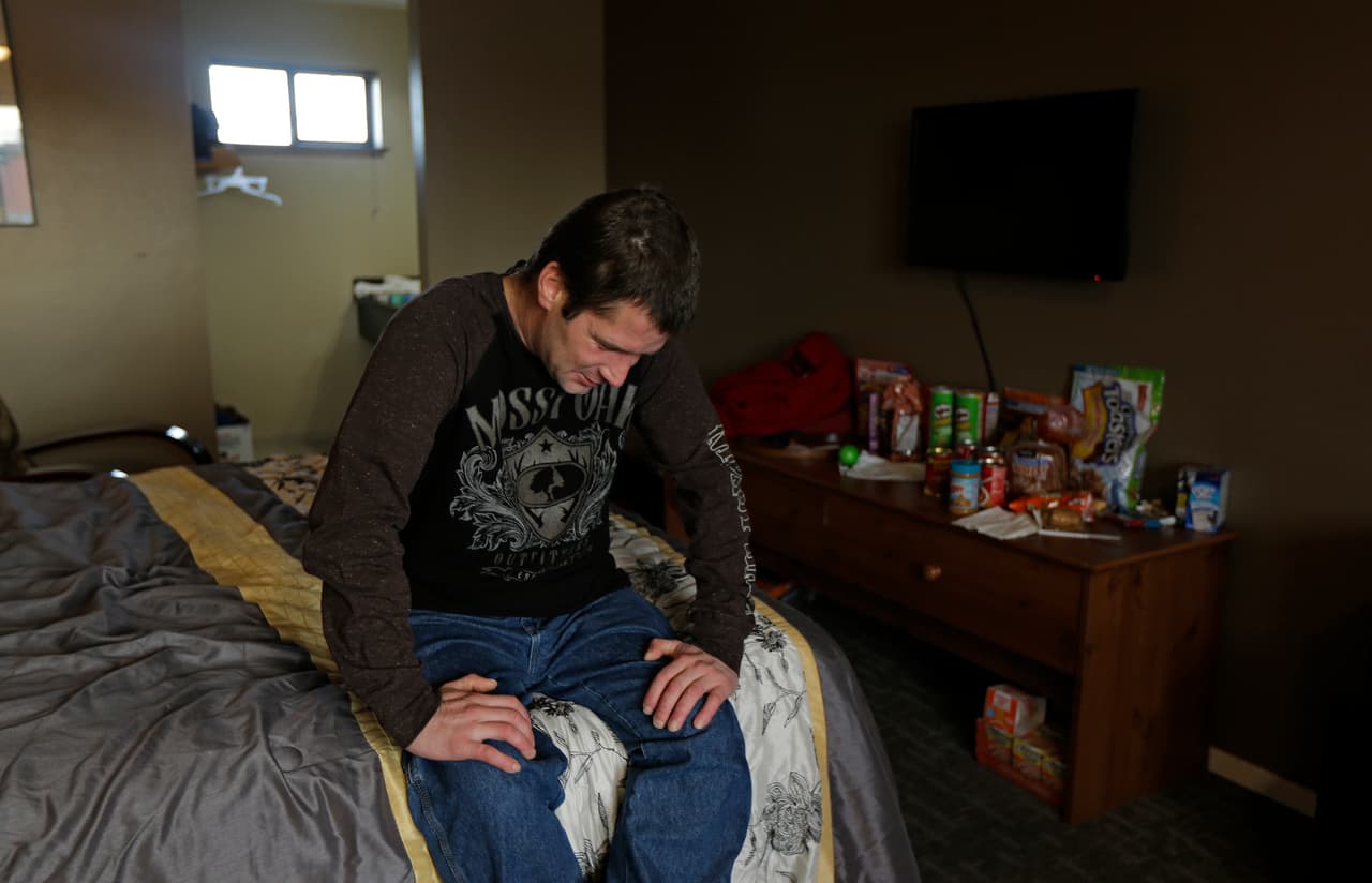 In this MON., Dec. 4, 2017 photo, Joshua Rape sits on his bed in the motel where he was living while waiting to move into an apartment paid for with a housing voucher in Everett, Wash. For years, Rape's life was a revolving door of drug use, jail stints, homeless shelters, and street-wanderings, until a specialized team of mental health professionals, housing and recovery experts, social workers and police officers worked to build a relationship with him. (AP Photo/Ted S. Warren)