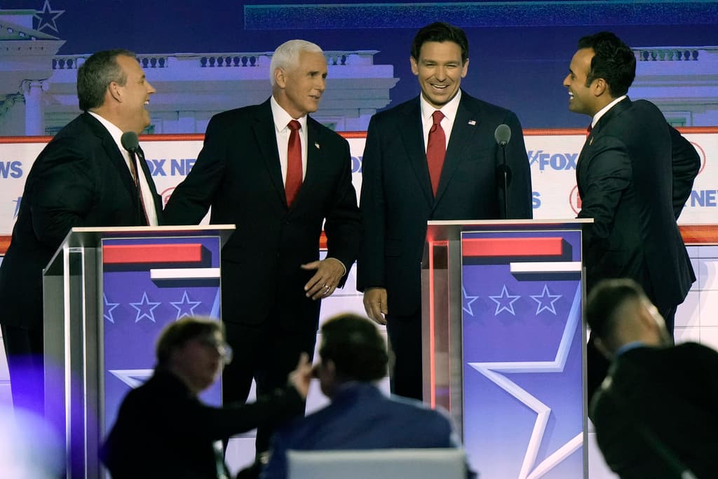 El exgobernador de Nueva Jersey Chris Christie, el exvicepresidente Mike Pence, el gobernador de Florida Ron DeSantis y el empresario Vivek Ramaswamy conversan durante el receso en un debate de las primarias presidenciales republicanas.