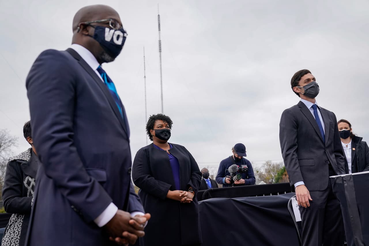 La demócrata Stacy Abrams y los candidatos Jon Ossoff y Raphael Warnock escuchan al presidente electo Joe Biden en un mitin de campaña en Atlanta donde se encontraban los líderes del partido que busca hacer historia el 5 de enero.