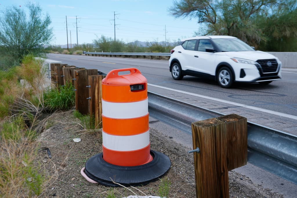 Un lector de matrículas utilizado por la Patrulla Fronteriza oculto dentro de un cono de tráfico captura a los vehículos que pasan por la autopista AZ 85, en Gila Bend, Arizona, el martes 21 de octubre de 2025.