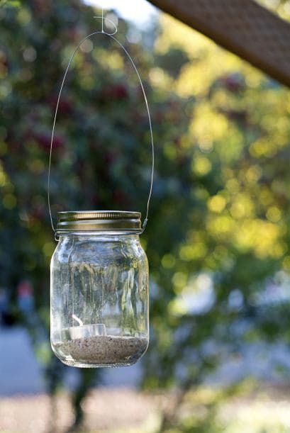 Iluminada. Si eres fan de las pequeñas velitas, utilízalas para una decoración de cuento de hadas. Ponlas en recipientes transparentes para decorar las mesas, cuélgalos de árboles o úsalos para iluminar el camino de entrada a la casa o los escalones del jardín.